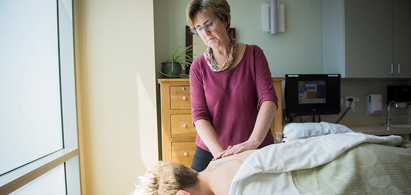 Massage therapist working with patient