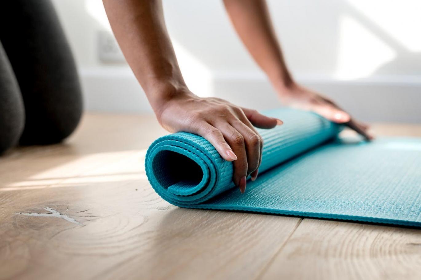 Woman rolling up a yoga mat