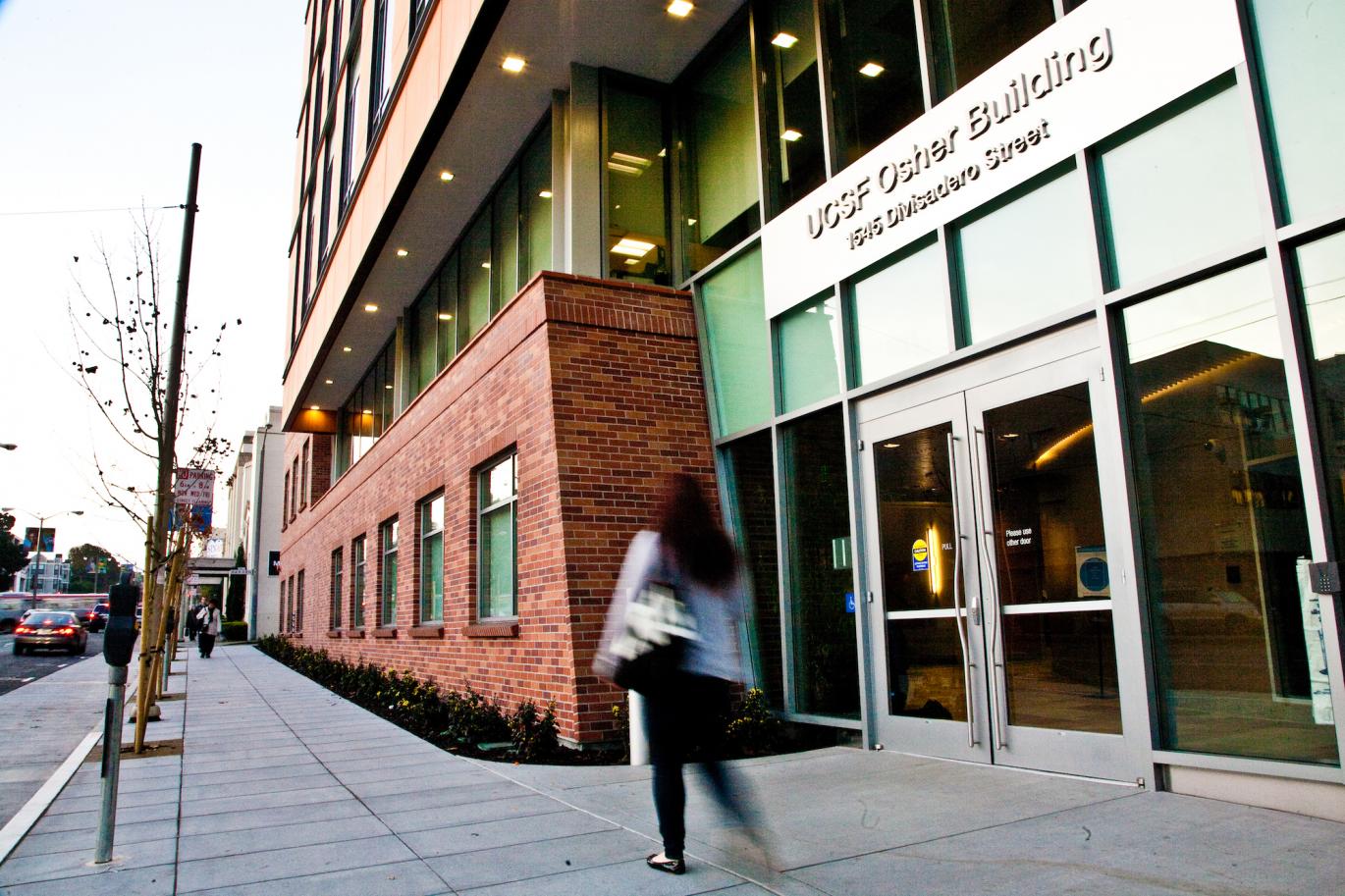 Person walking in front of the Osher Building